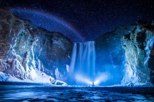 Night photo of a waterfall in Iceland, which is on the travel bucket list, too