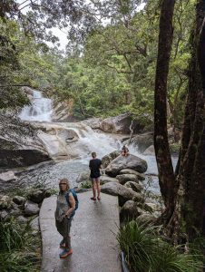 Photo of Josephine Falls in Australia, with people on a paved walking track leading to the river bank.