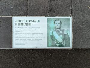 Photo of a sidewalk plaque in Sydney, Australia commemorating an attempted assassination of Prince Alfred, a British prince.