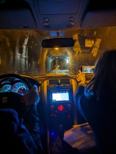 Photo of a car dashboard and windshield, with a view of a one-way tunnel in Iceland. Photo (c) 2023 Carol Van Natta.